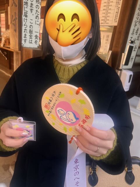大宮八幡宮で絵馬やお守りを持ってる娘